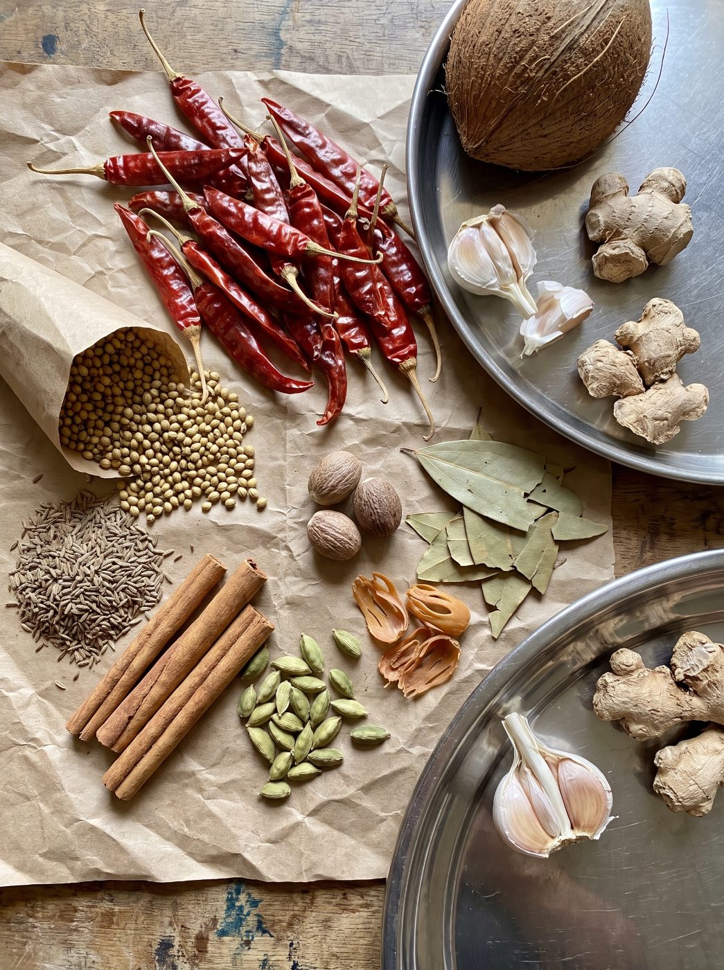 Whole spices laid out on brown paper